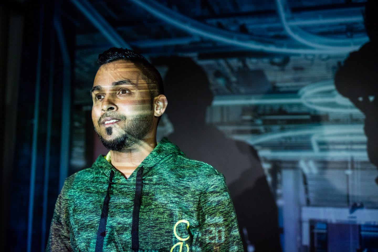 Man smiling with a projection behind him