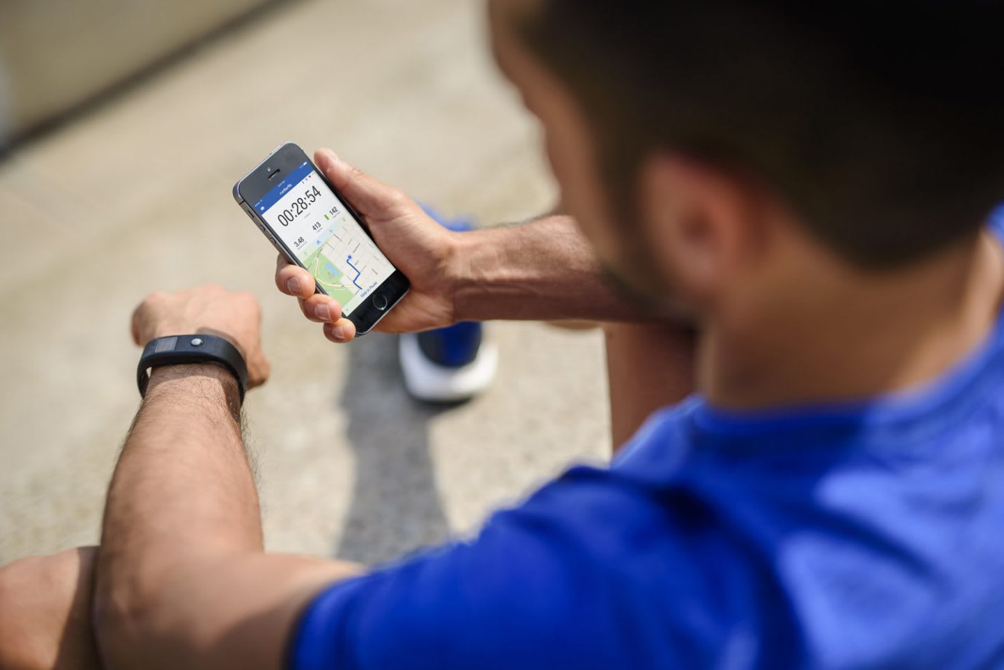 man in running clothes looking at the runtastic app on his phone