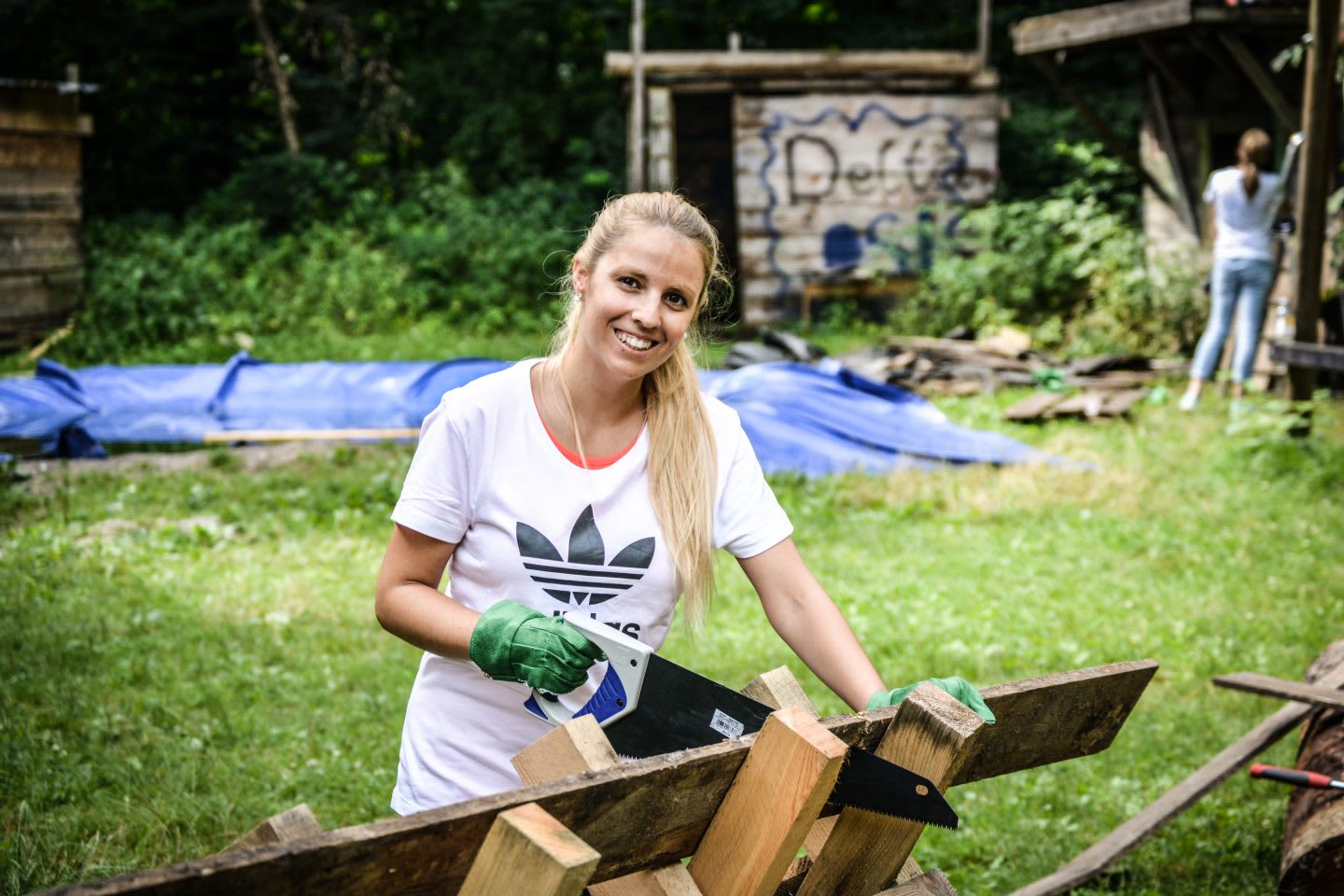 woman with a saw is cutting wood