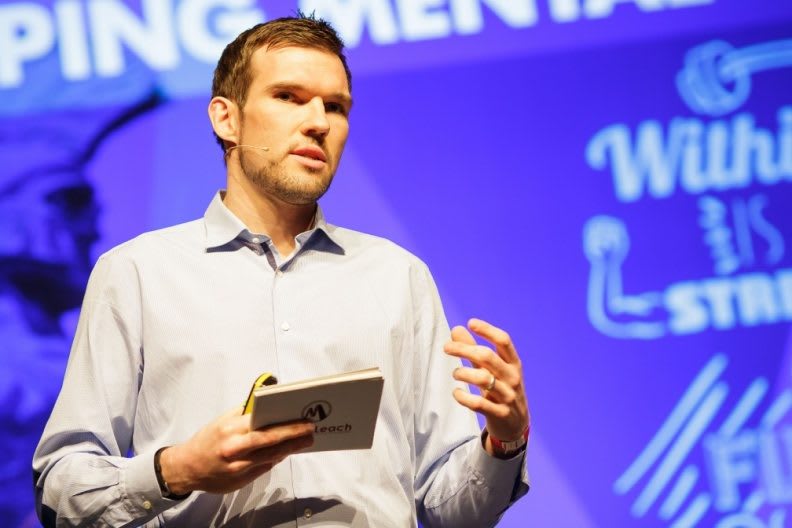 man with notes in his hand speaking and gesturing mastering public speaking