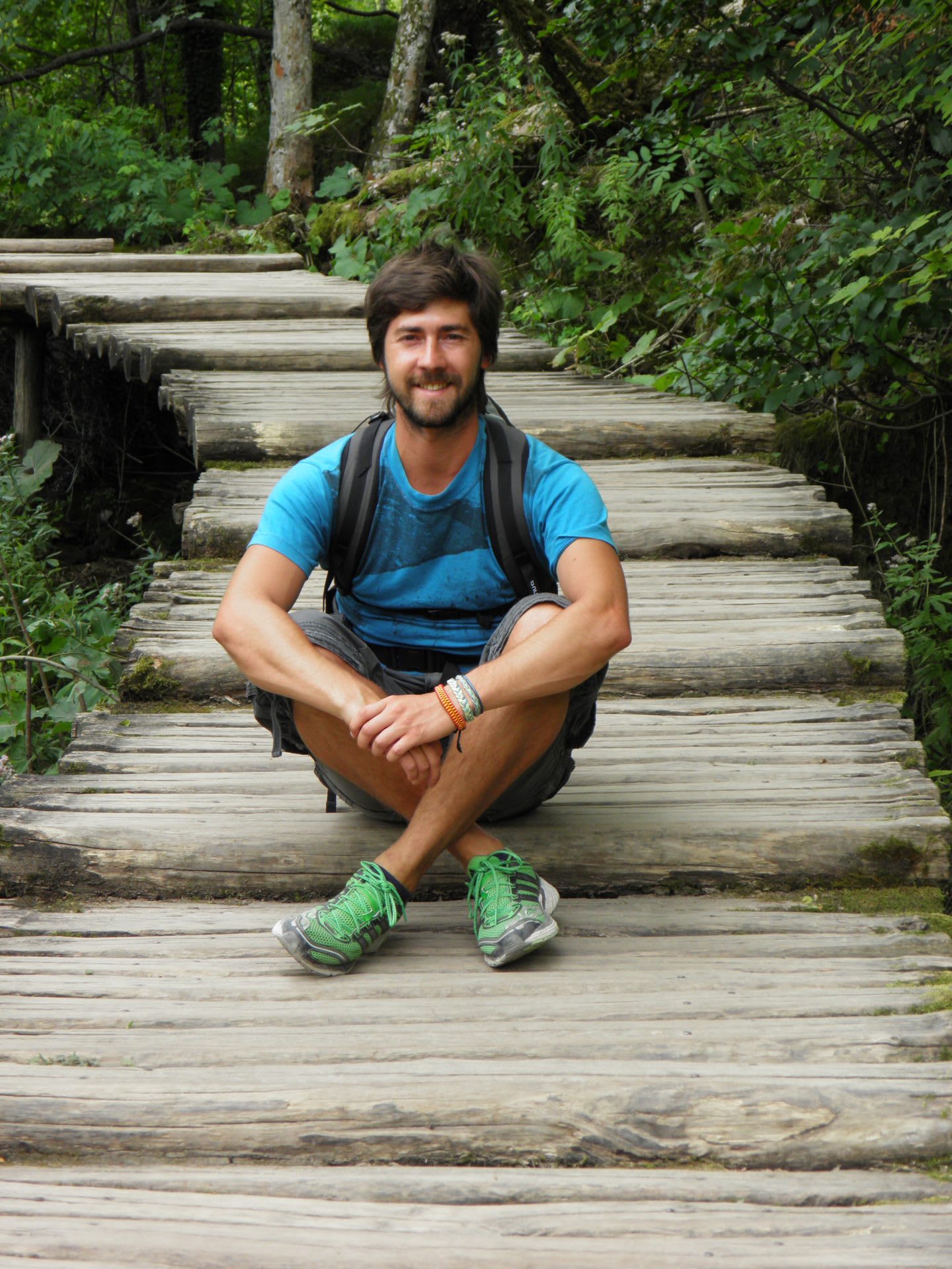Guy sitting on the stairs smiling into the camera.
