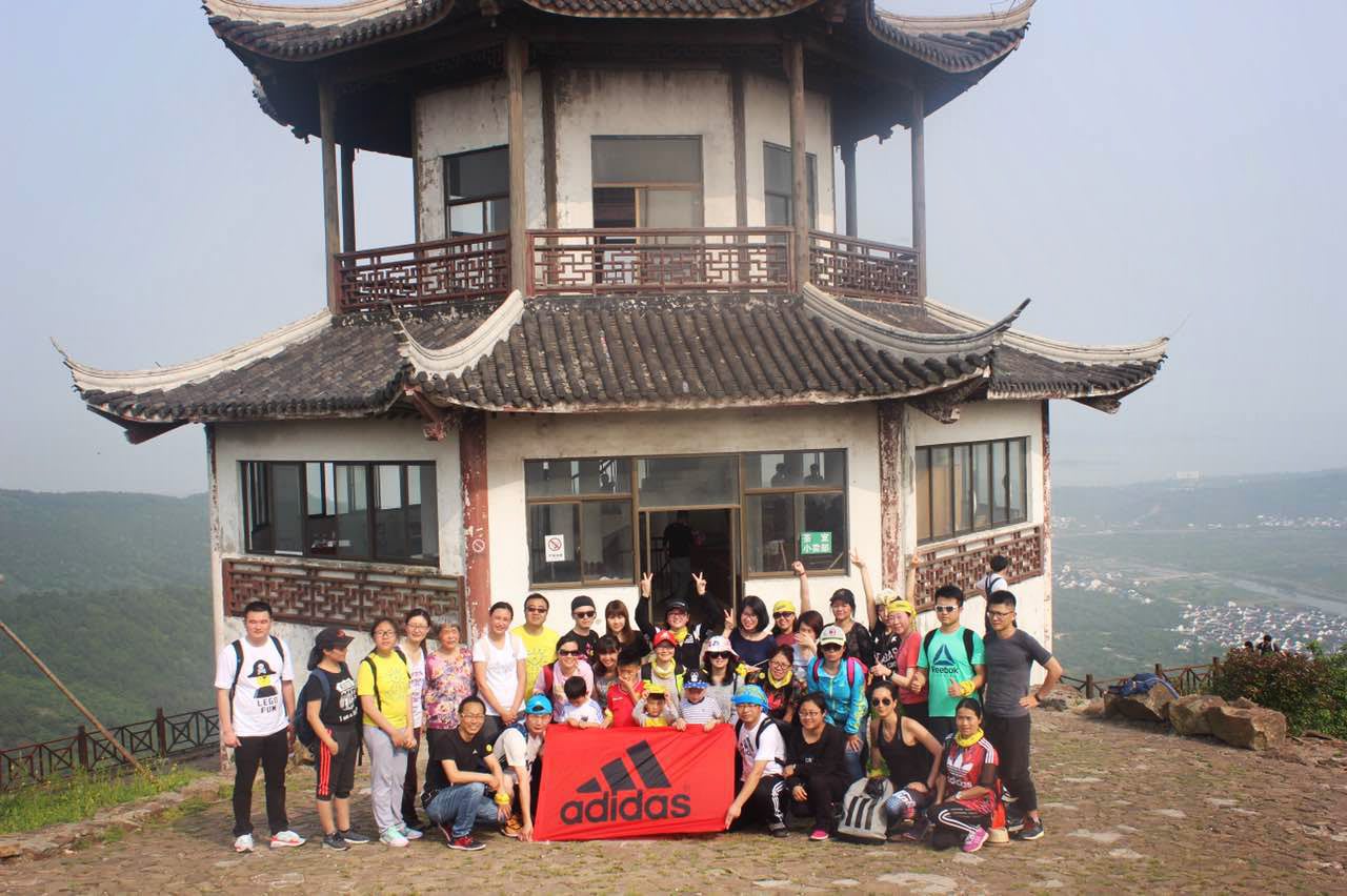 team posing on mountain with adidas flag trainee shanghai experience