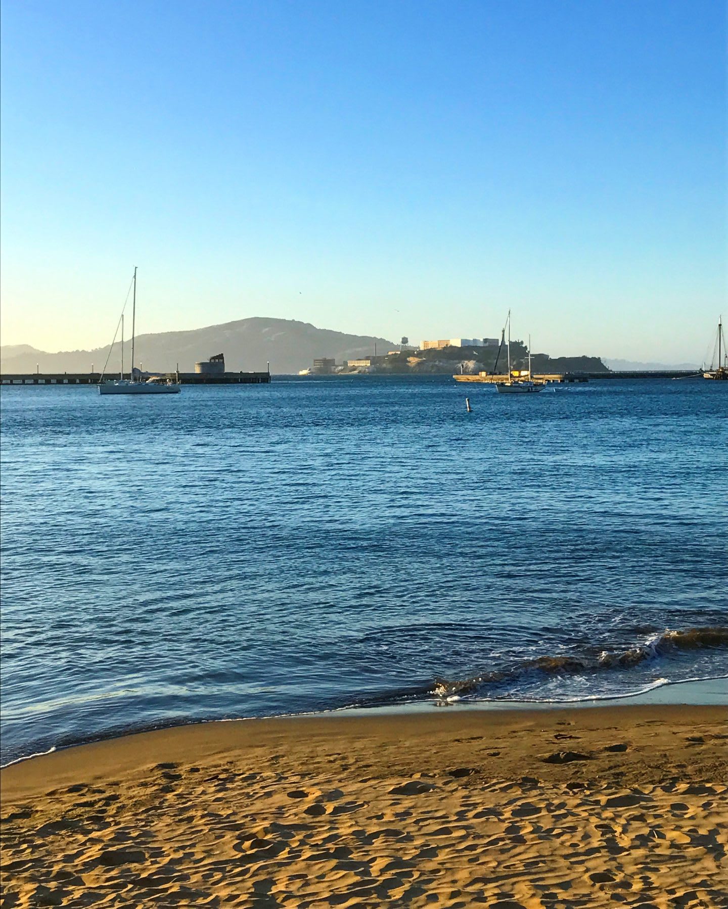 beach in the sunrise_looks calm_port in the background