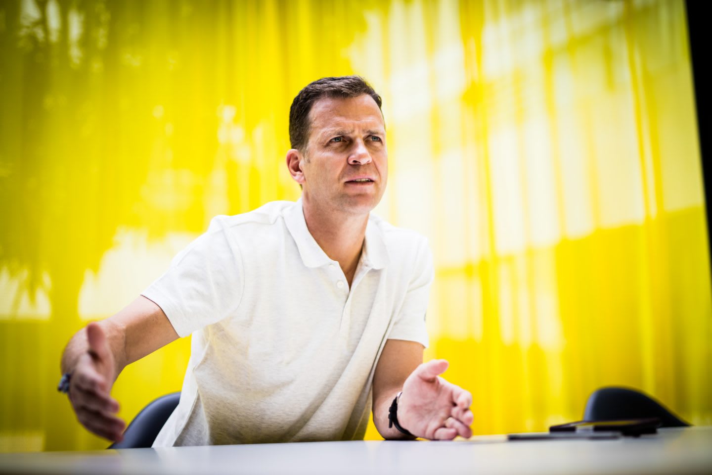 Oliver Bierhoff wearing white poloshirt giving an interview in front of yellow background at adidas for GamePlan A on team culture and the German national team, Oliver Bierhoff_DFB_Interview_adidas_Team Culture