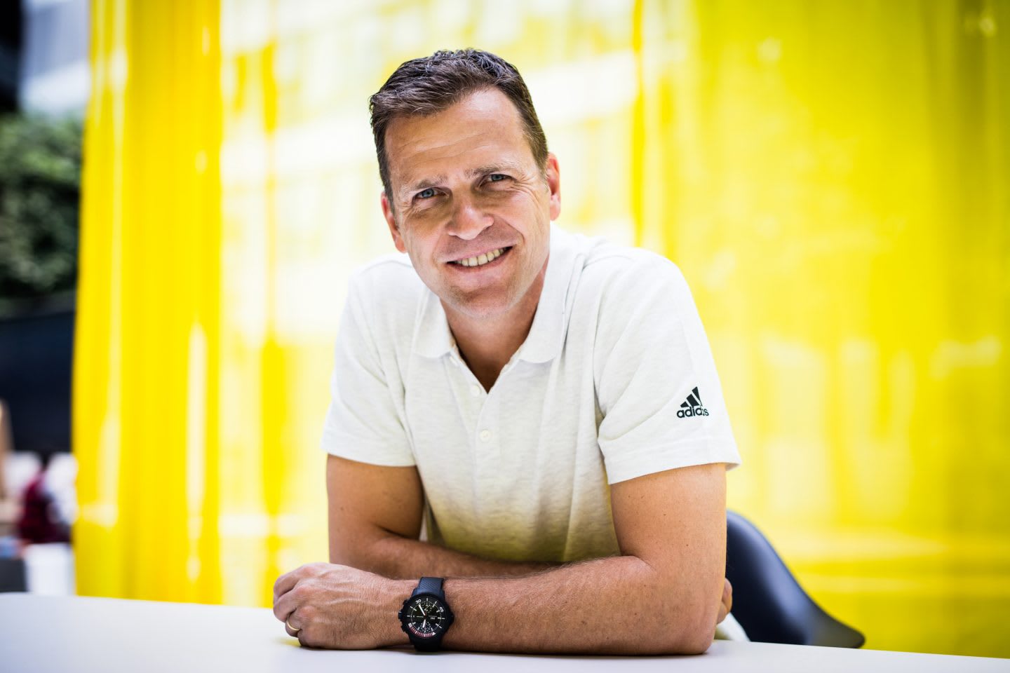Oliver Bierhoff wearing white poloshirt giving an interview in front of yellow background at adidas for GamePlan A on team culture and the German national team, Oliver Bierhoff_DFB_Interview_adidas_Team Culture
