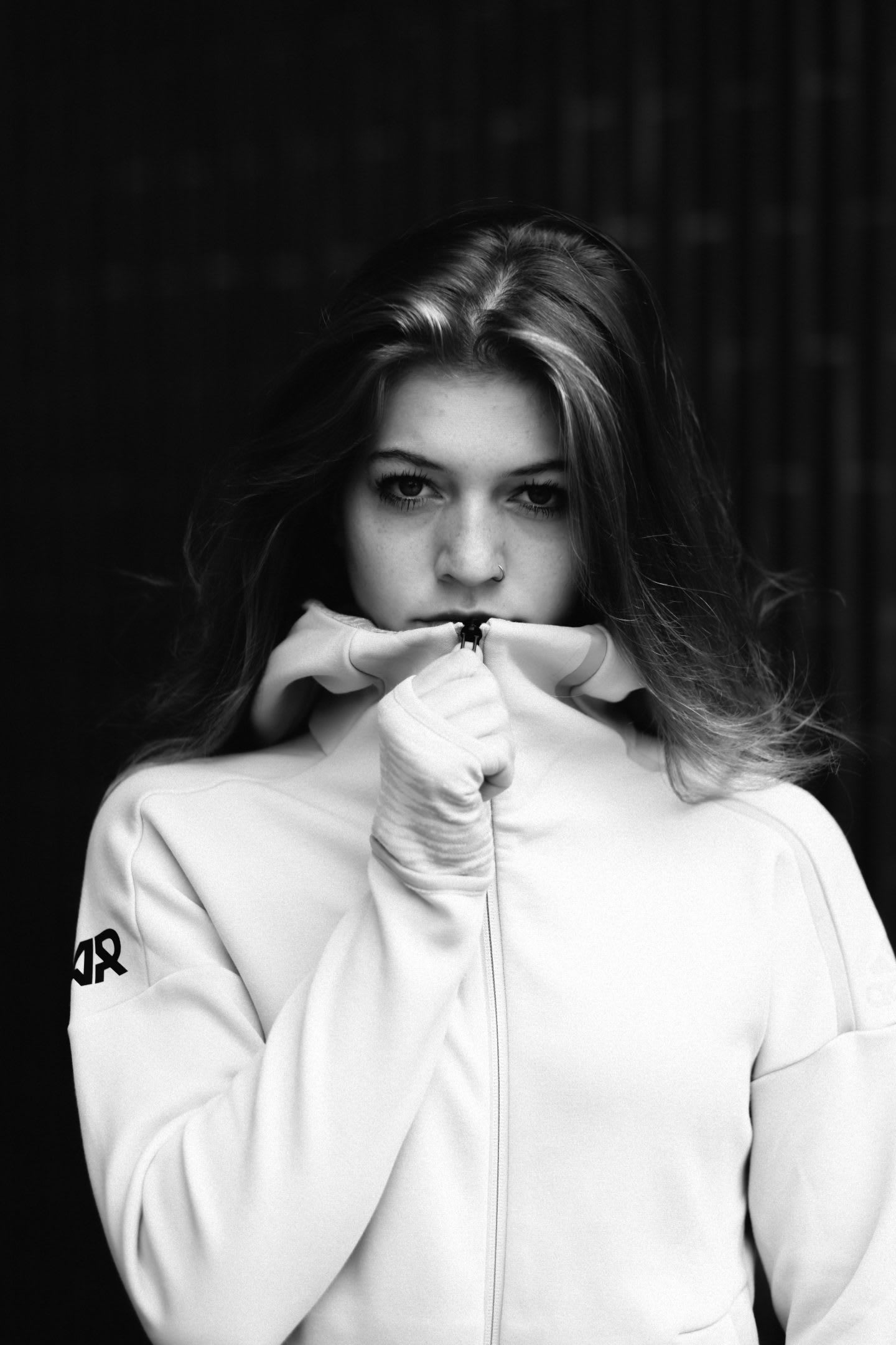 Black and white picture of a woman wearing a white adidas Runners track top and standing in front of black background, Claudia Sch+¦ttli-Serano_adidas Runners_GamePlan A