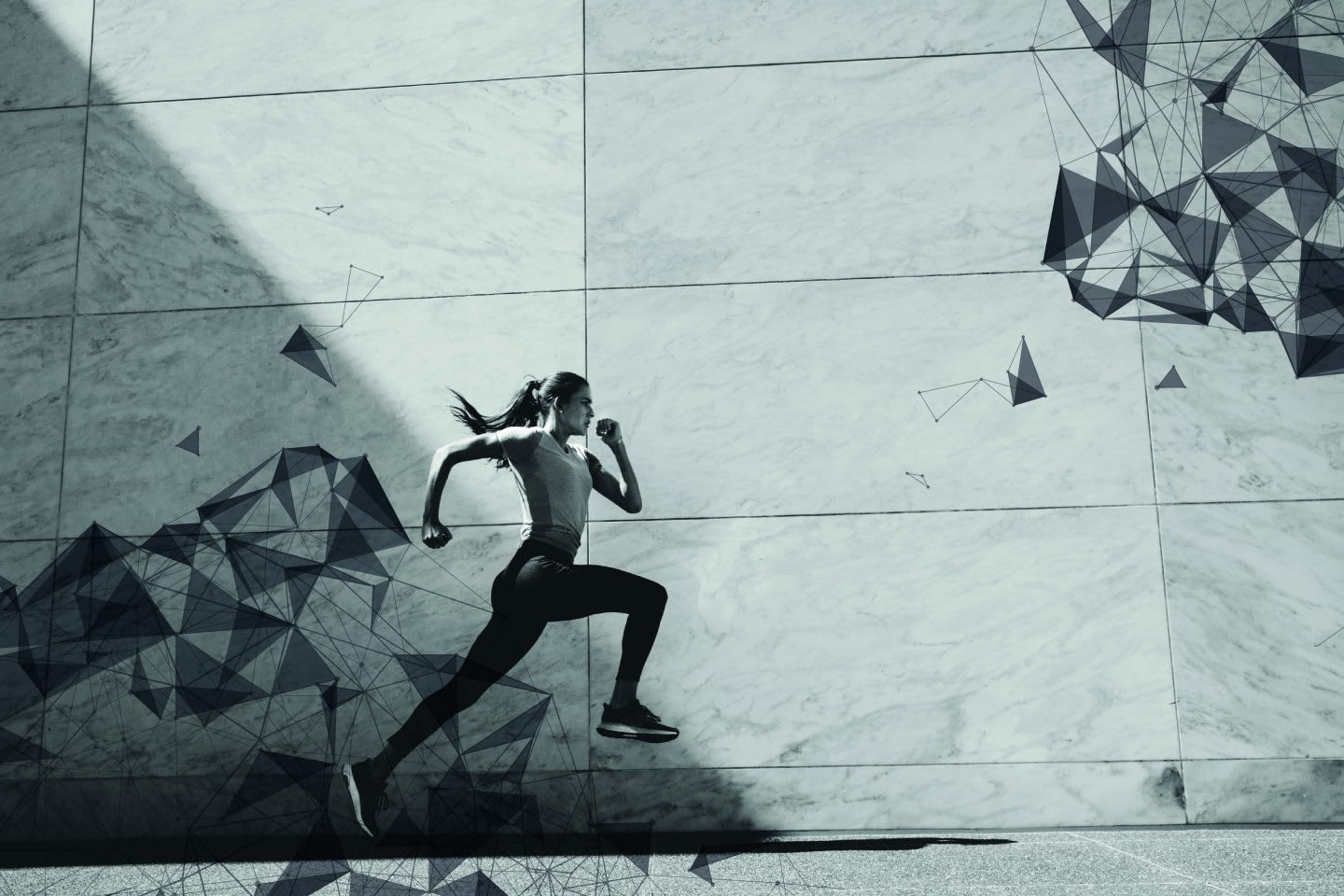 Woman running against a cement backdrop.
