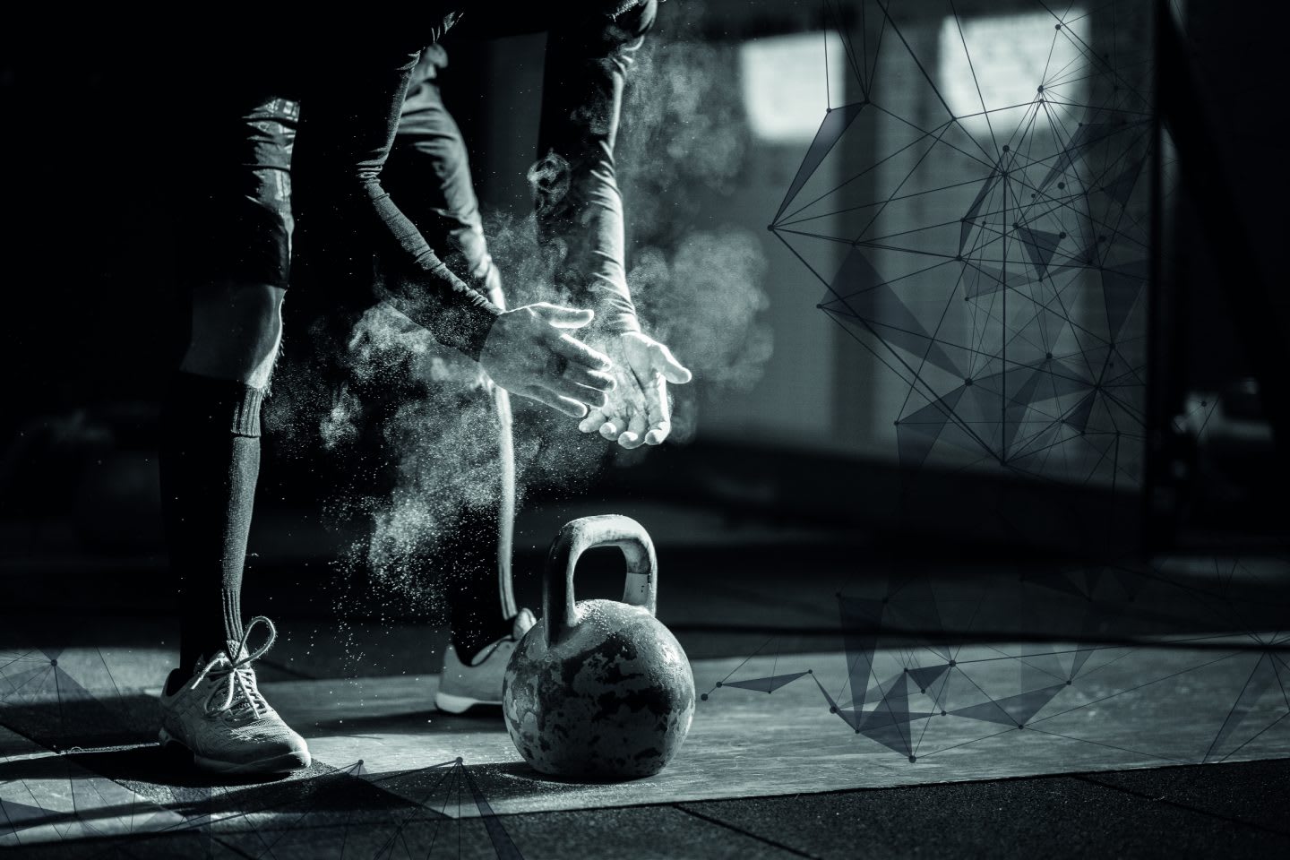 Hands in a puff of a chalk cloud a pair of hands reaches for a kettle bell.