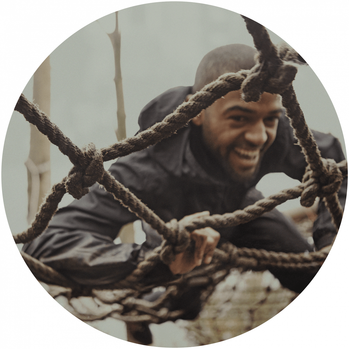 A man climbing on a net during an obstacle race. team building, team event, Obstacle Race_team building_climbing a net