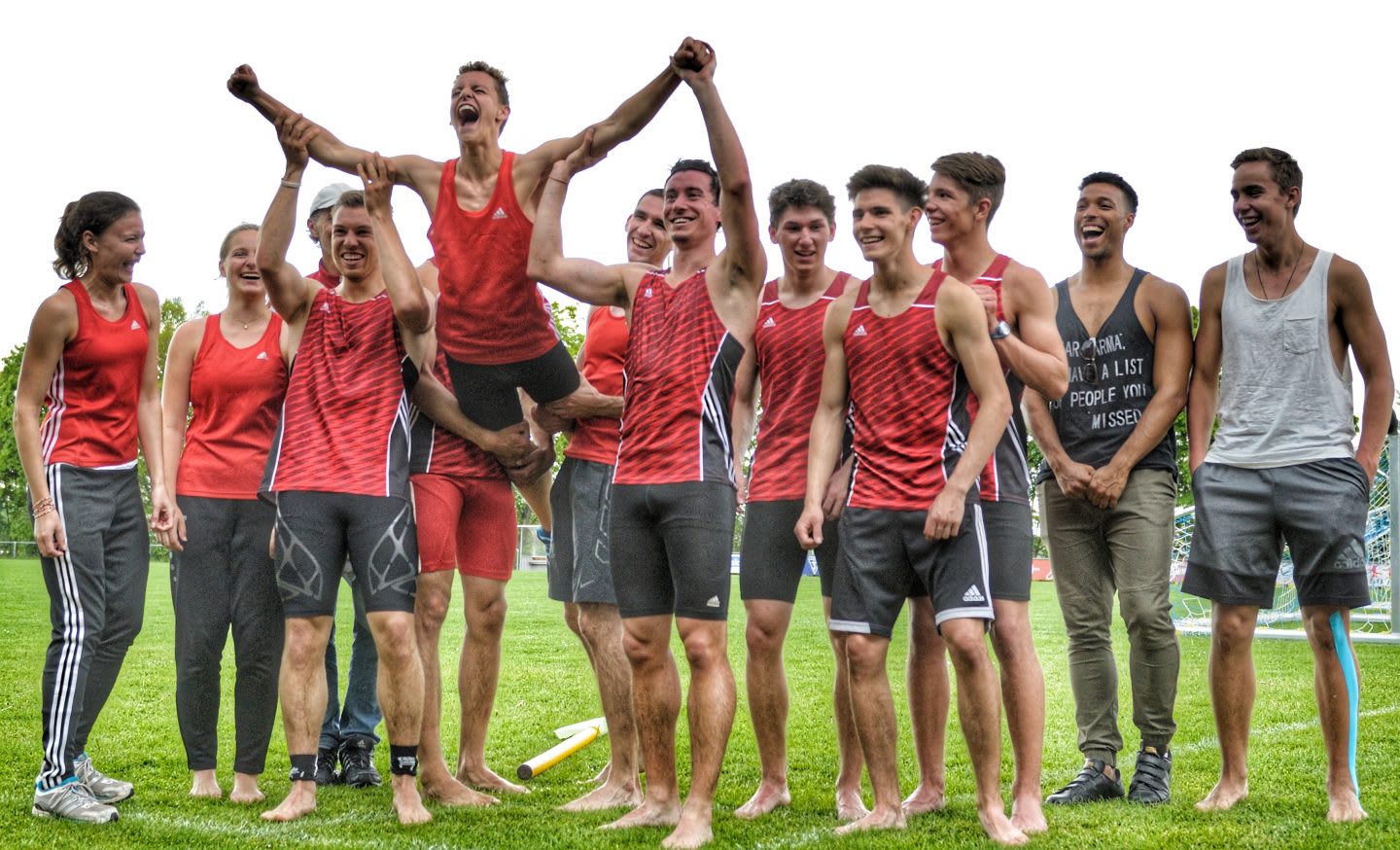 A team on a field lifts one of the members out of excitement