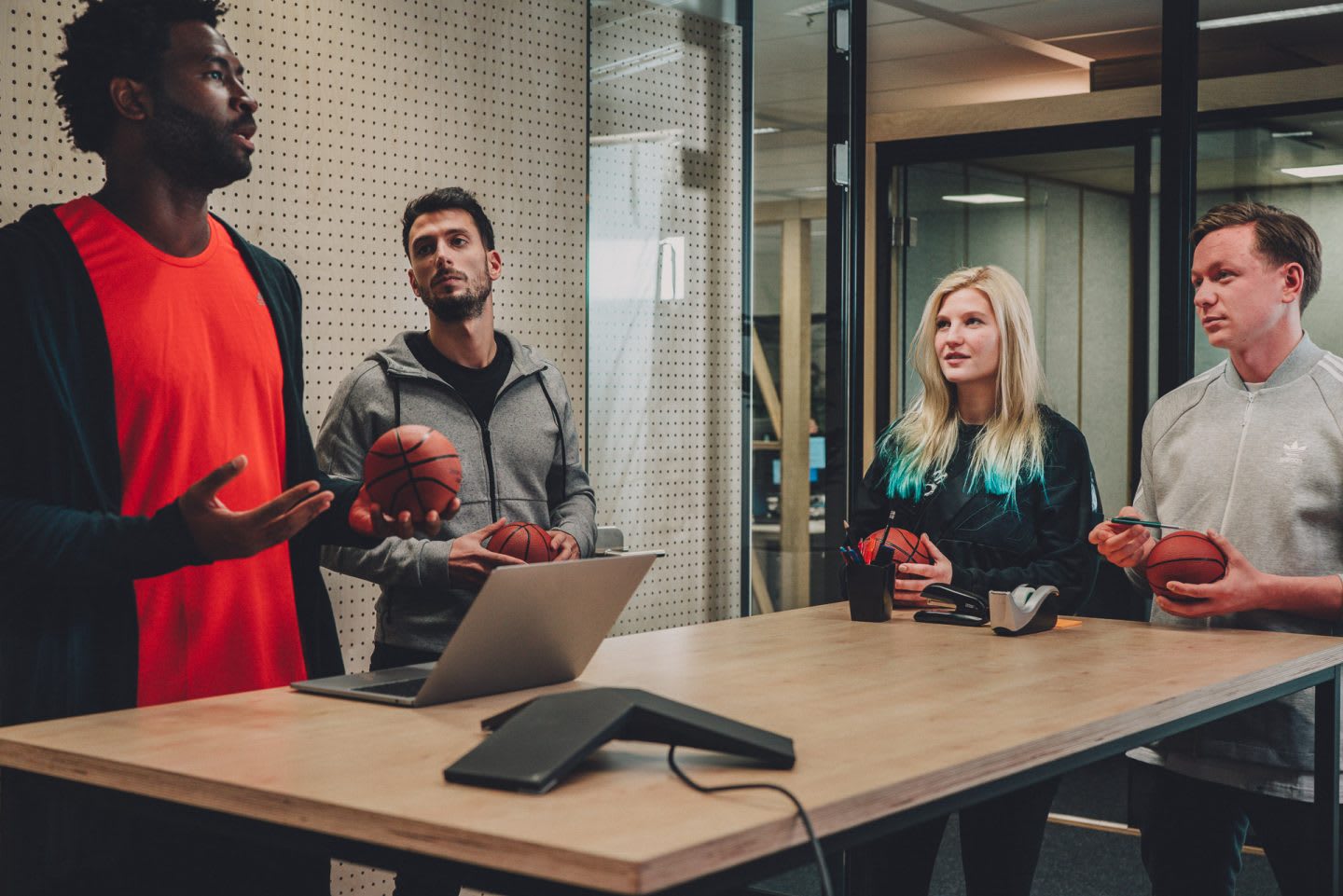 Employees brainstorming ideas during a meeting in a modern office environment. HereToCreate, adidas, teamwork, basketball, digital, leadership, strategy