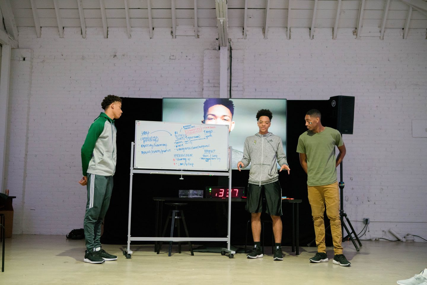 Three young boys stand beside a whiteboard presenting their ideas. teamwork, confidence, teaching, learning