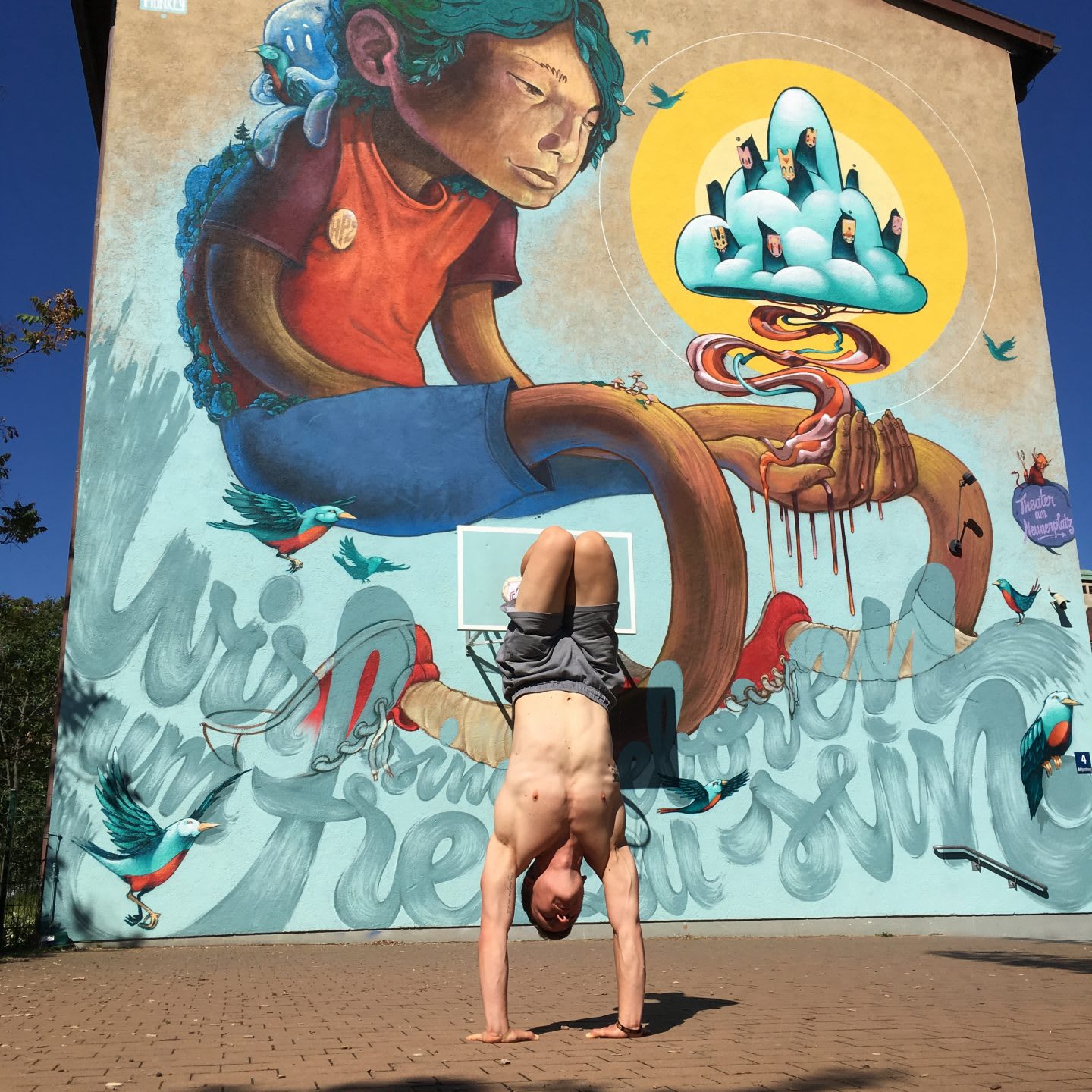 Man does handstand in front of mural. Handstand, Mural, Man