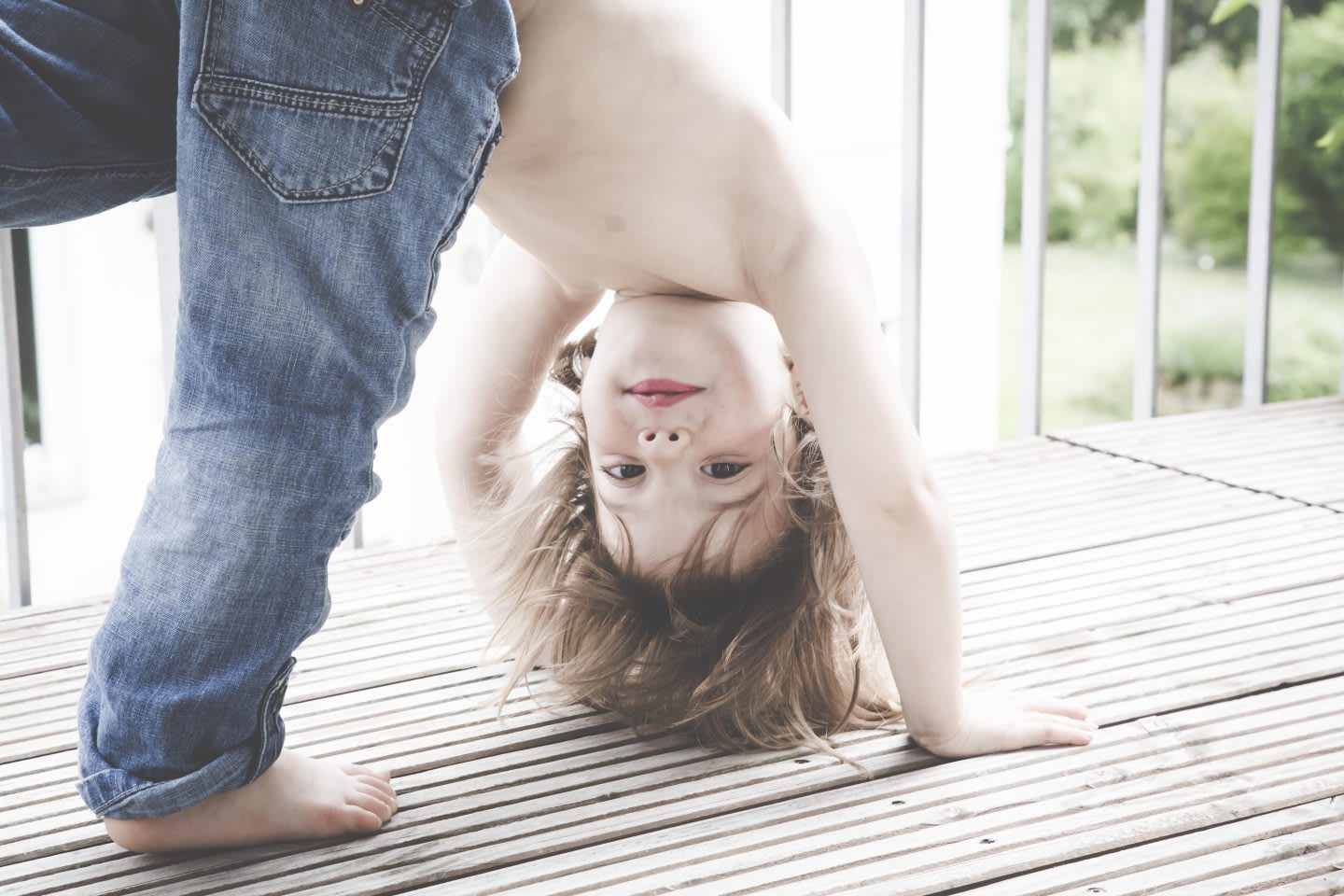 Portrait of little girl doing handstand on balcony. learning, career, GamePlan A