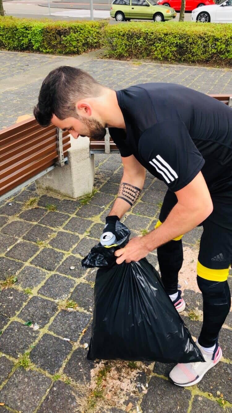 Young man wearing adidas UB19 collecting trash while runnig which is also called plogging