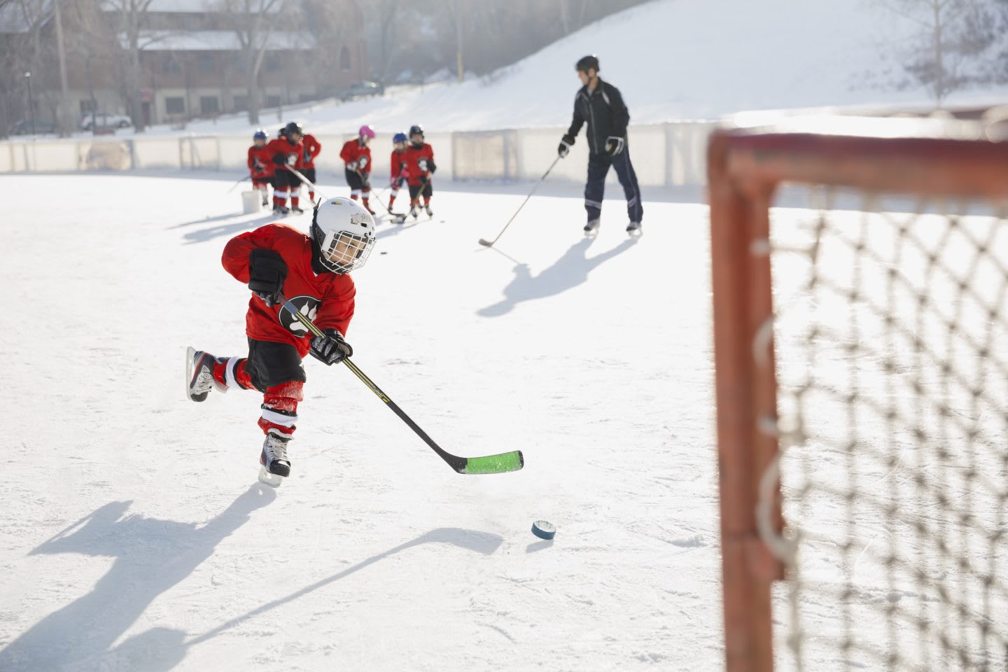 Hockey player practicing on ice rink with his coach