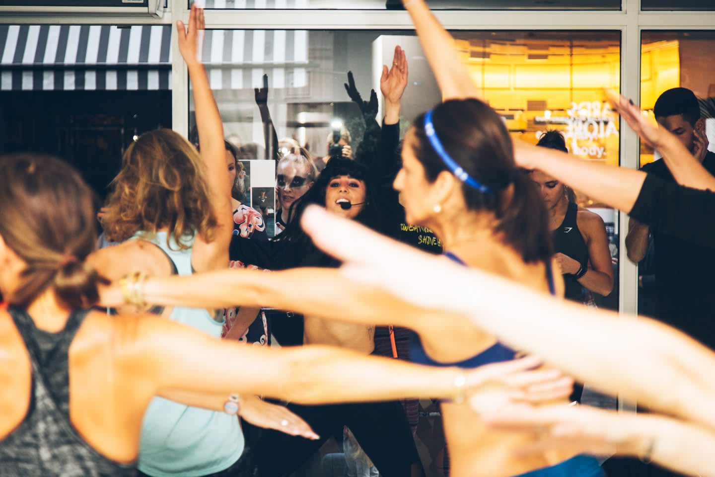 A forest of bare arms fill the screen as people workout to music bunched close together. Wellness, Gameplan A.