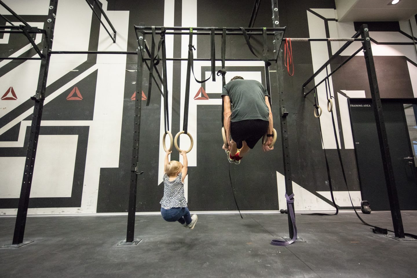 man working out with child in a crossfit gym