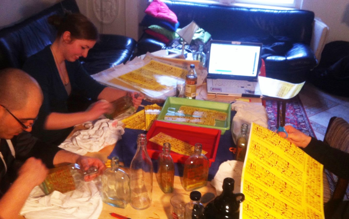 The soulbottle team decorating glass bottles in a living room.