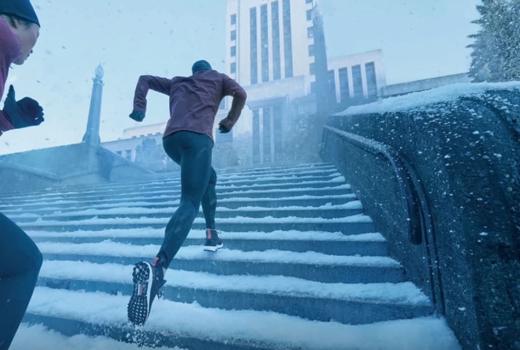 person running up stairs covered with snow, holiday season
