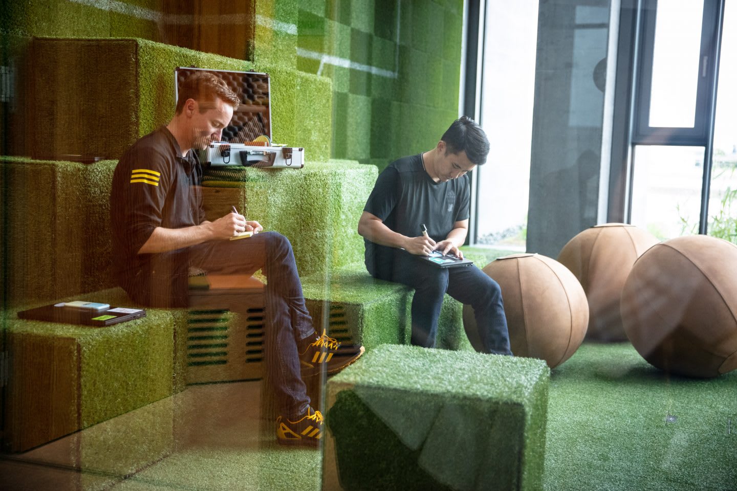 Two adidas employees sitting in a meeting room and writing. career choices, working in adidas, adidas recruitment, career development, GamePlan A