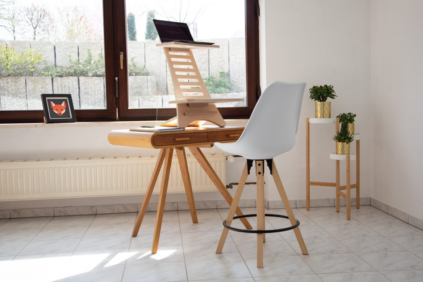 Homeoffice workspace with wooden table and setup to work while standing and looking out of window. working from home with kids. Habits and routines, Parenting, coronavirus.