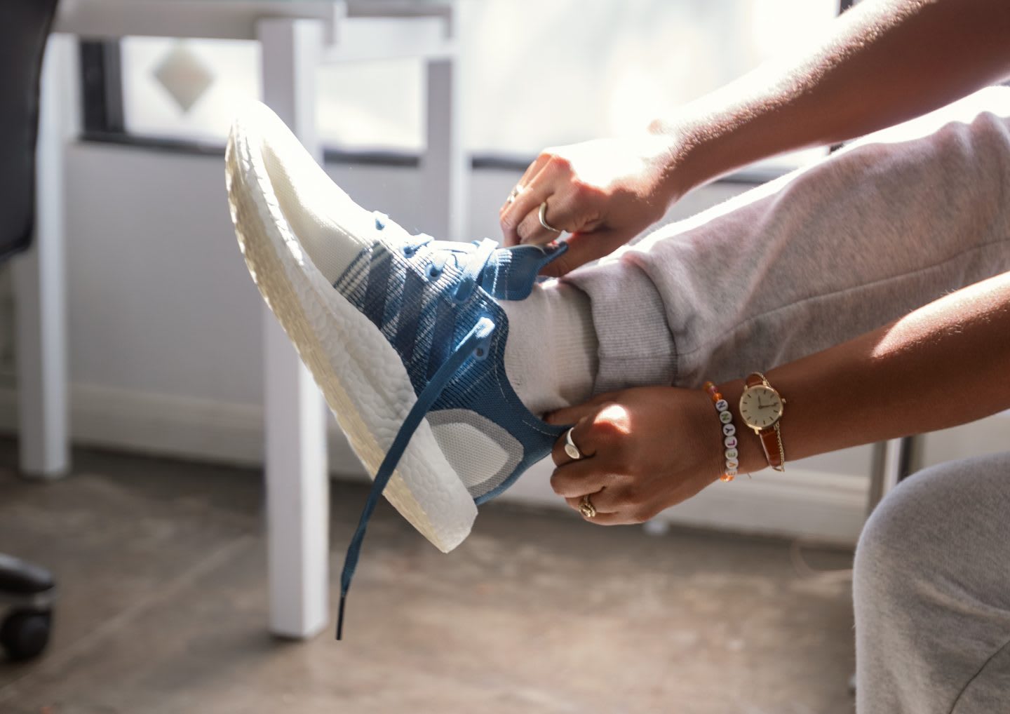A person is putting on an adidas Futurecraft.LOOP running shoe. plastic waste, adidas Futurecraft Loop, sustainability, 2 generation, GamePlan A