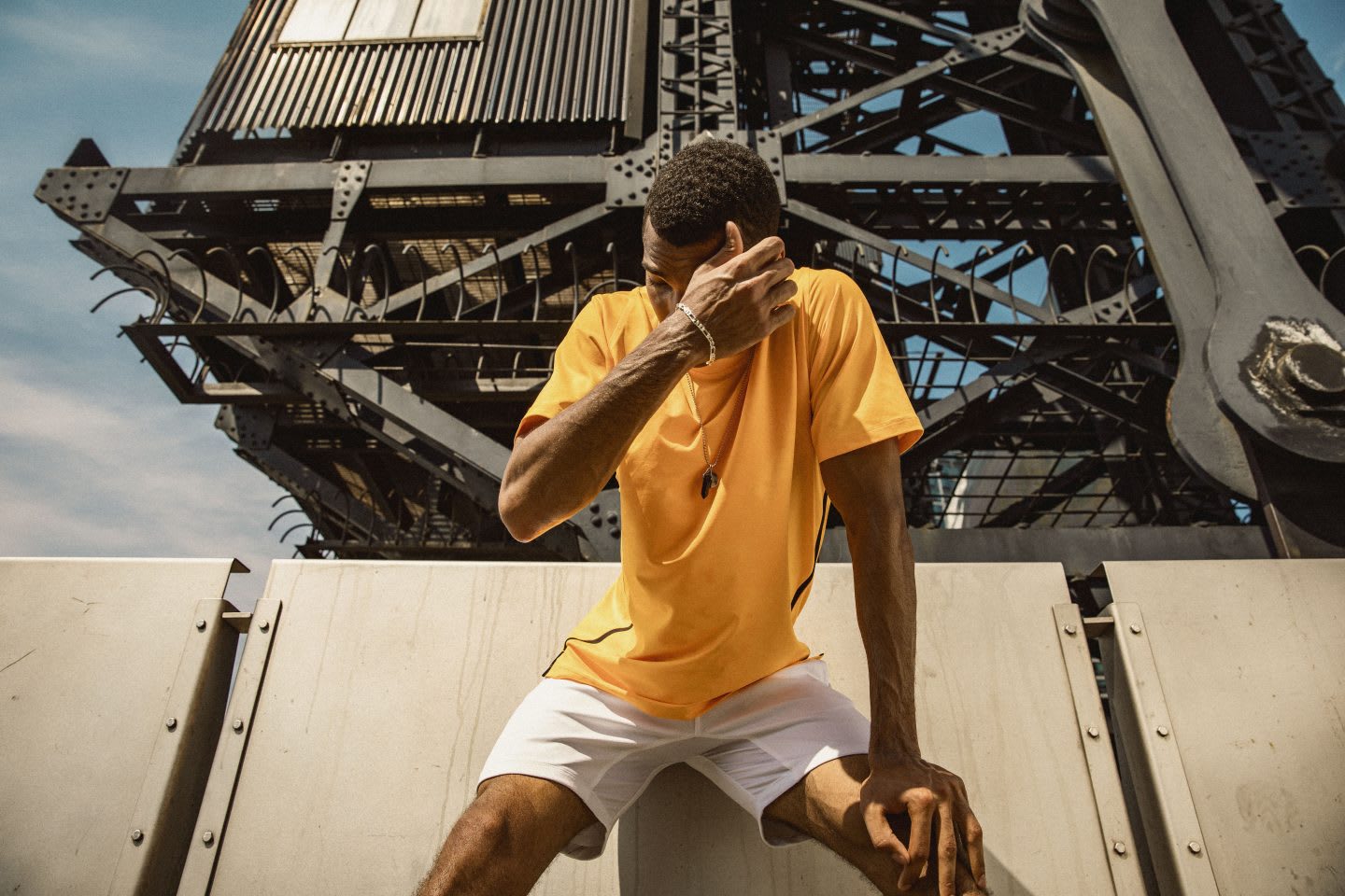 Man wearing yellow t-shirt kneeling over wiping sweat off his face on a sunny day, exercise. fitness, sport, adidas, GamePlan A