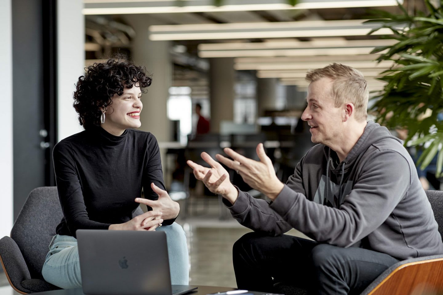 Man explaining something to a female colleague during a meeting, teamwork, team, collaboration, office, work, adidas, employee