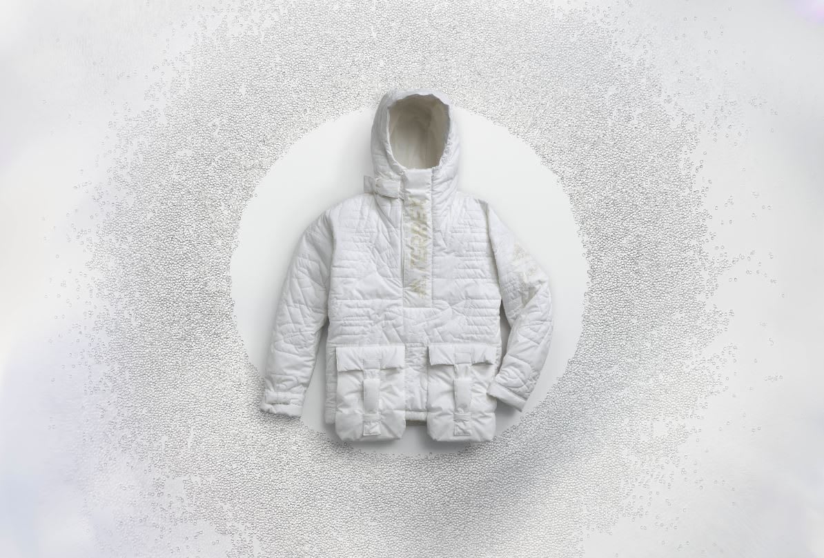 White winter jacket on white background surrounded by small pellets, FUTURECRAFT, LOOP, Anorak, ISPO, sustainability, fashion, adidas