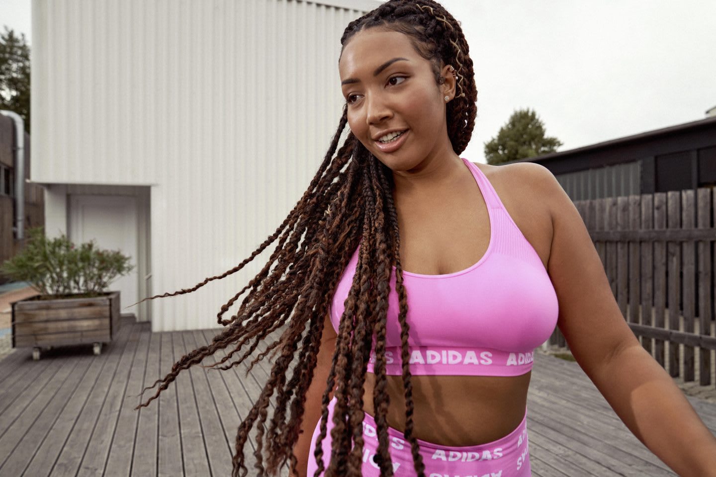 Woman in pink sports bra and leggings, plus-size. inclusive, sizing, adidas, training, apparel, workout, fitness, body, positivity