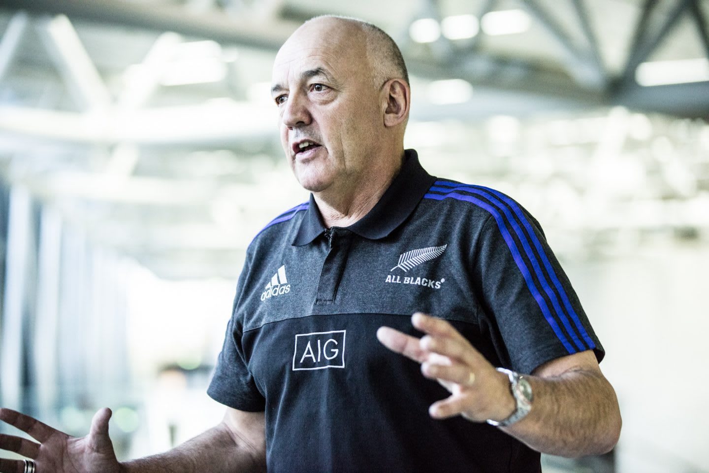 Man wearing All Blacks t-shirt talking while moving hands, Gilbert Enoka, mental, strength, rugby, coach, GamePlan A