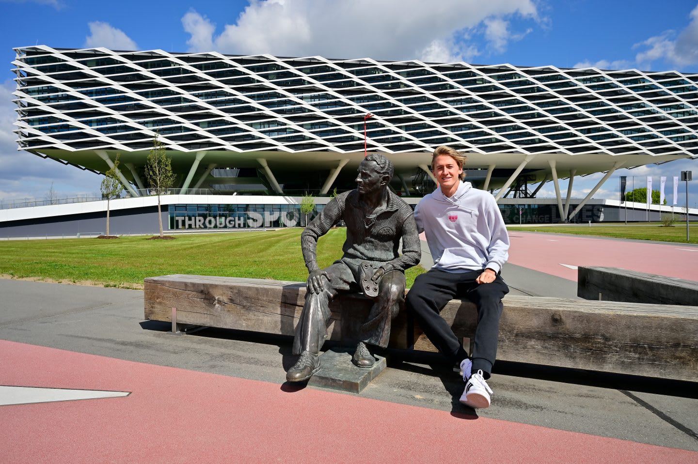 Sebastian Korda sits next Adi Dassler statue at the Headquarters in Herzogenaurach. Tennis, Adidas Headquarters, Herzogenaurach, Adi Dassler, Sebastian Korda