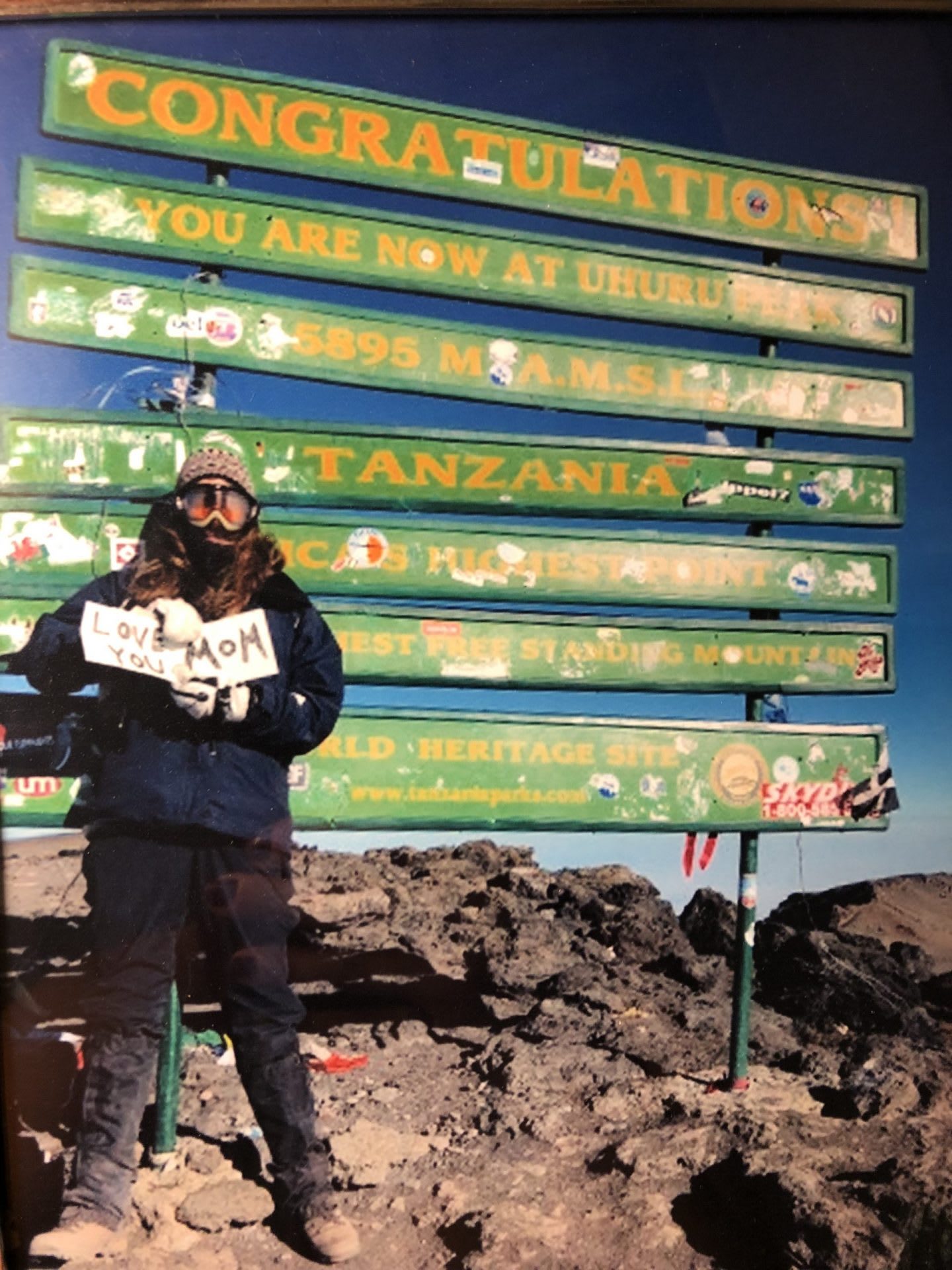 Woman standing on top of Kilimanjaro mountain holding a sign, Samantha Jacobs, adidas, employee, Senior Manager