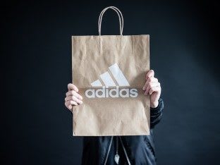 Person holding an adidas brown paper bag, sustainable, store, retail