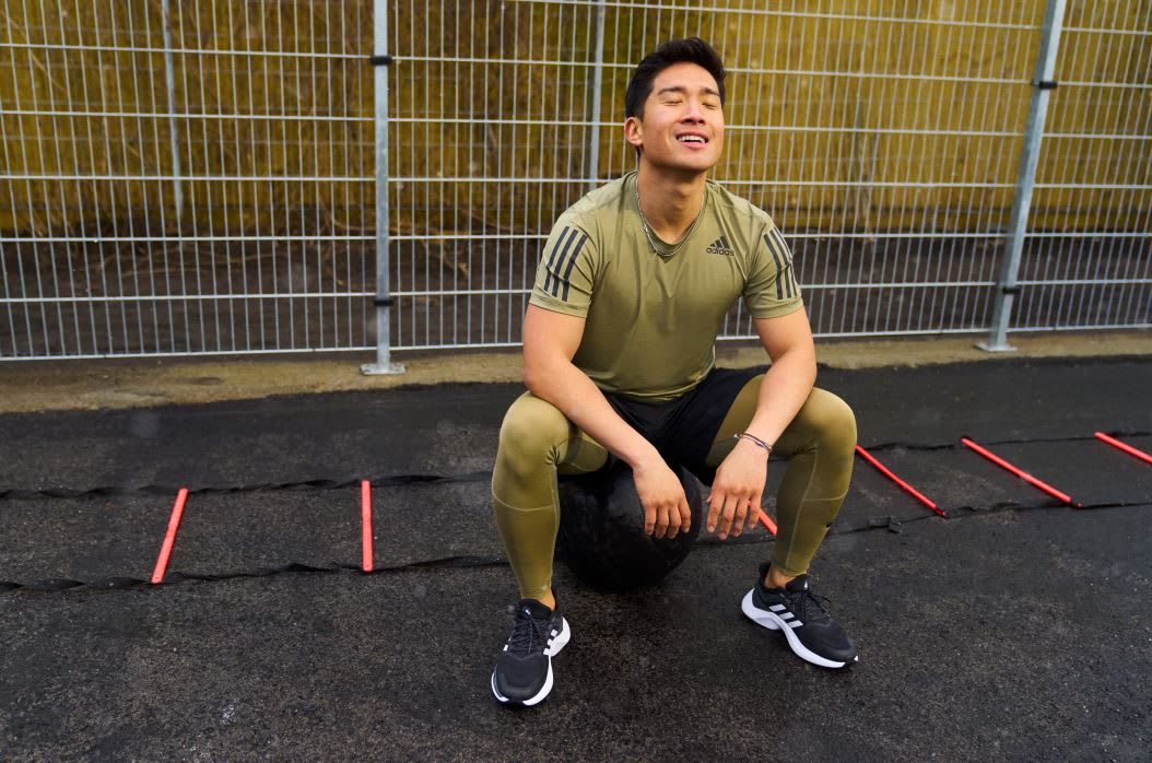 Man wearing green adidas sports t-shirt relaxing after workout in outdoor gym, adidas, sports, performance, exercise, fitness