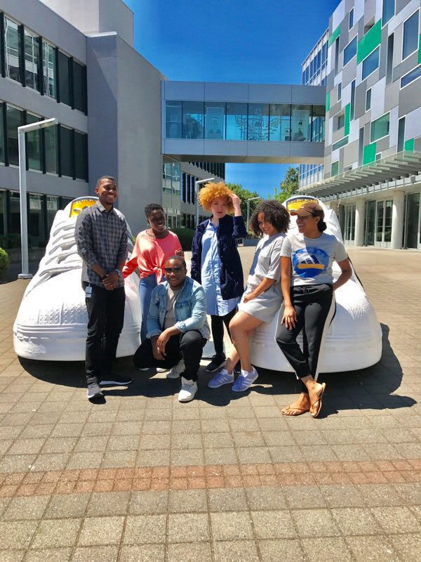 people posing on the PDX adidas campus outside in front of shoes