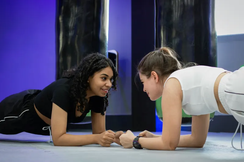 a trainer welcoming a new member into the weights area