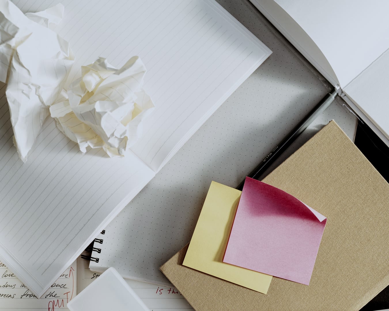 Scrunched up papers on a cluttered desk.