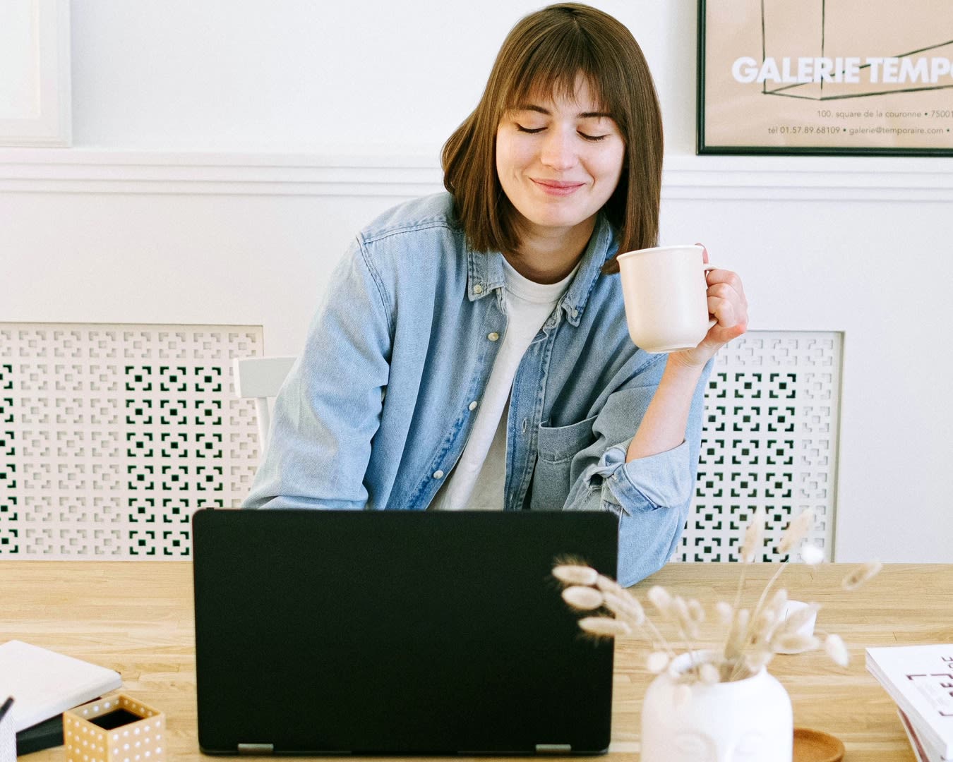 A client with a relaxed and content look sitting behind her laptop.