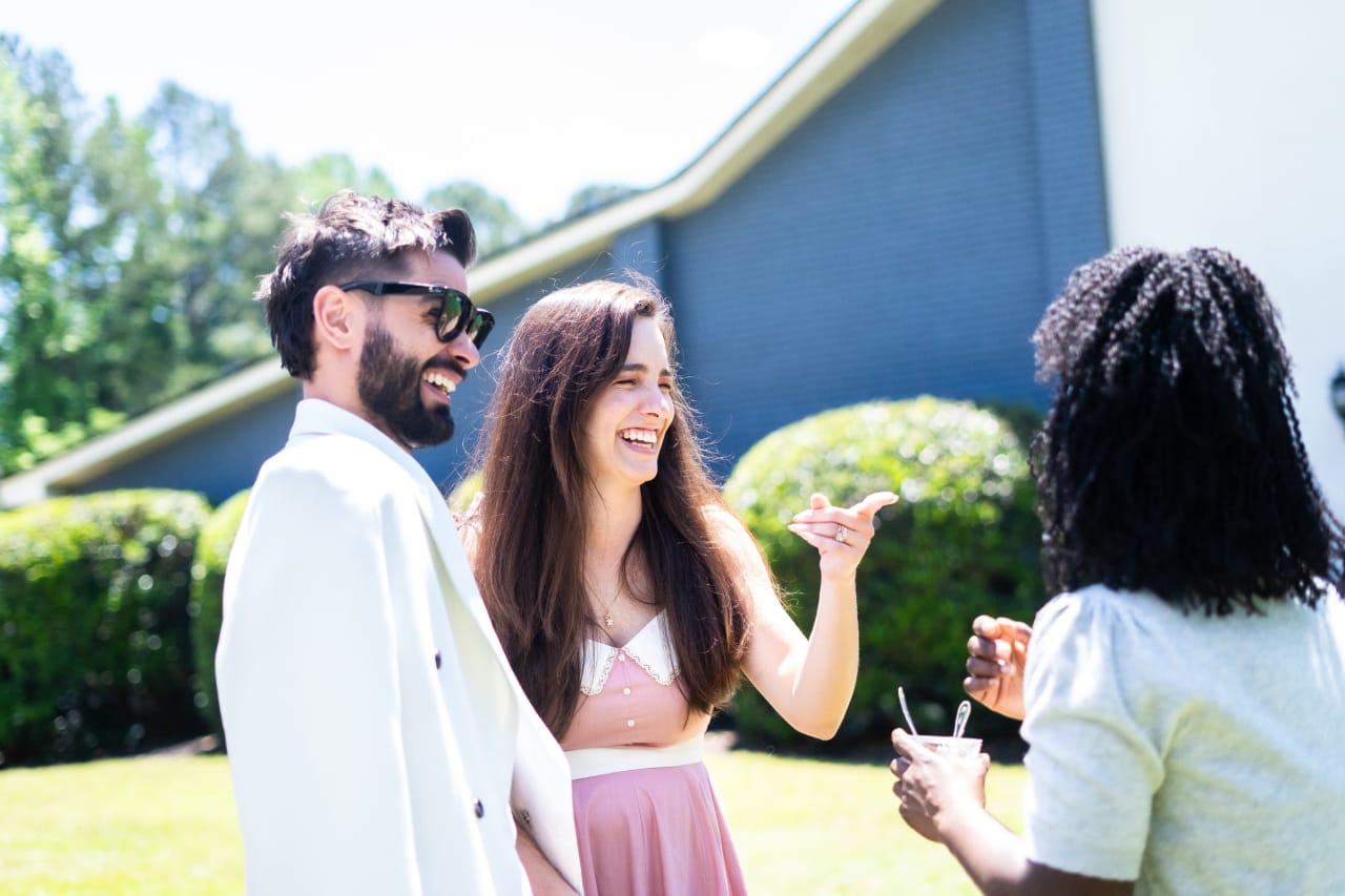 Friends chatting with drinks in the bright summer sun outdoors