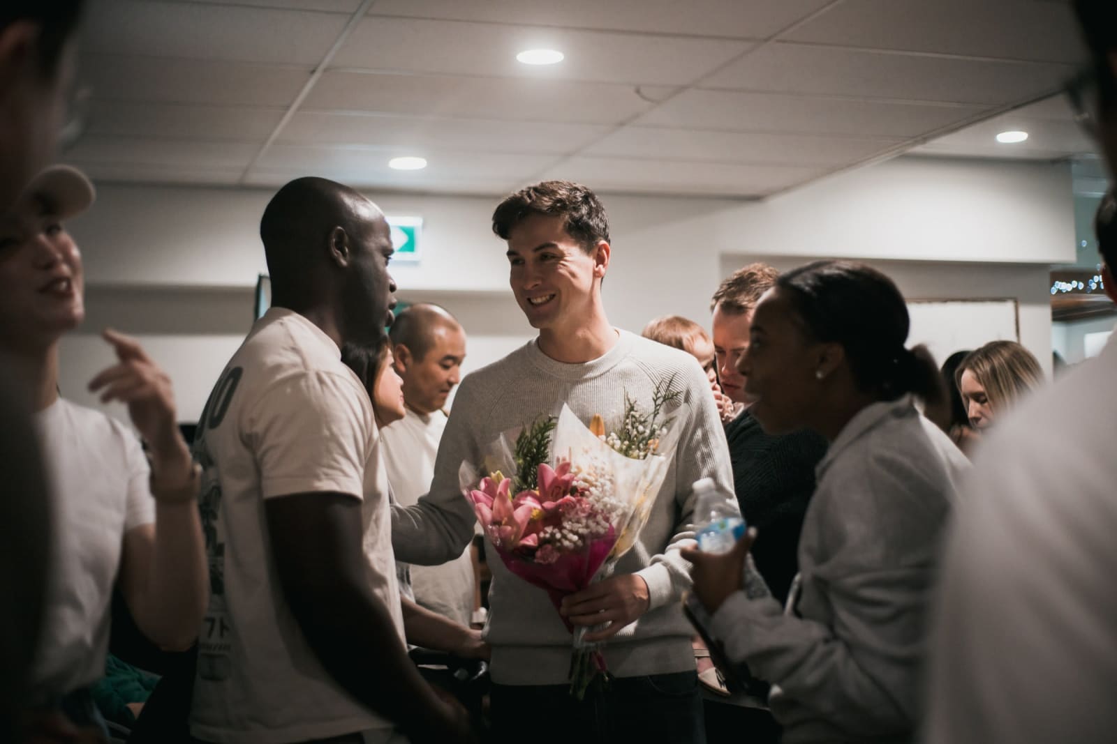 Black Man and Women Smiling With White Man In City Foyer