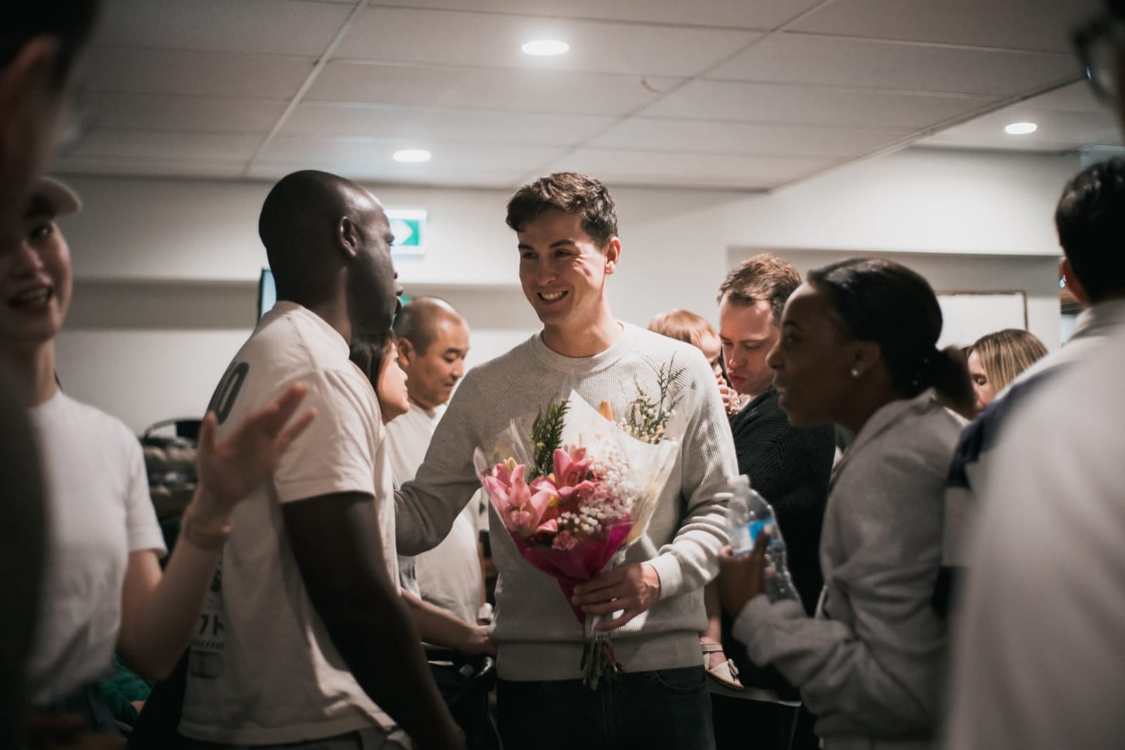 Black Man and Women Smiling With White Man In City Foyer