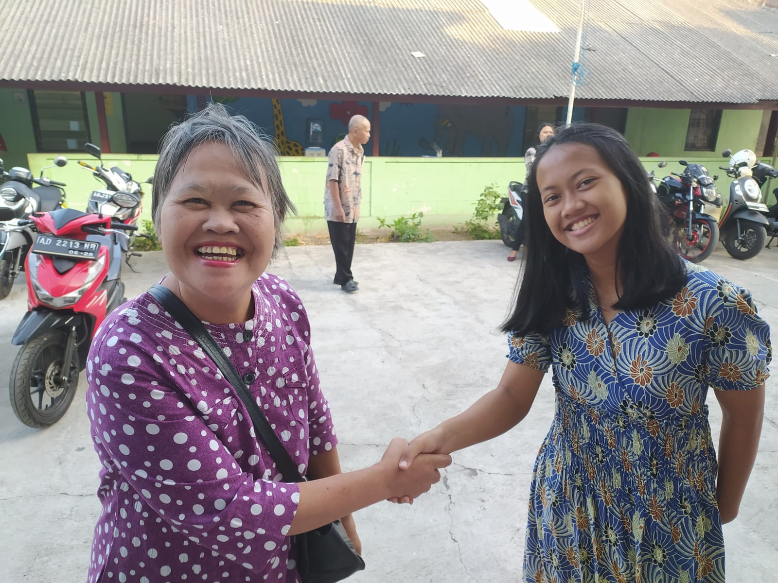 Cemani women shaking hands smiling