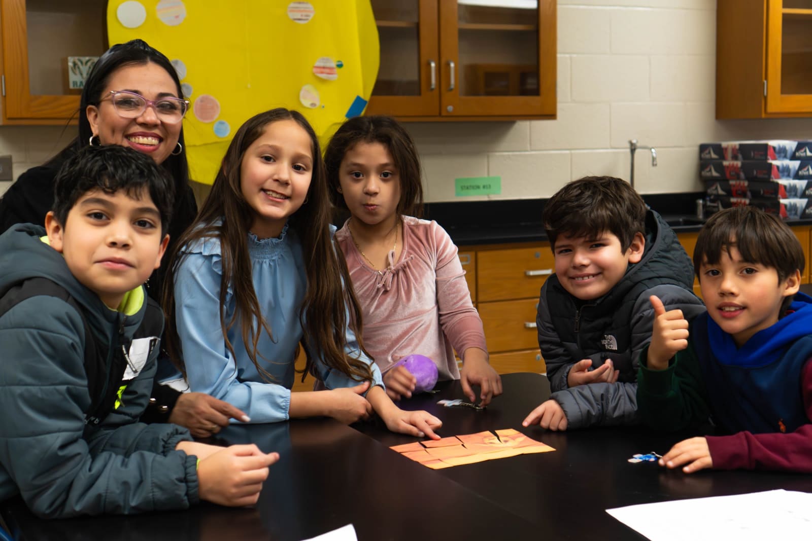 Leader with smiling kids at a table / grayson