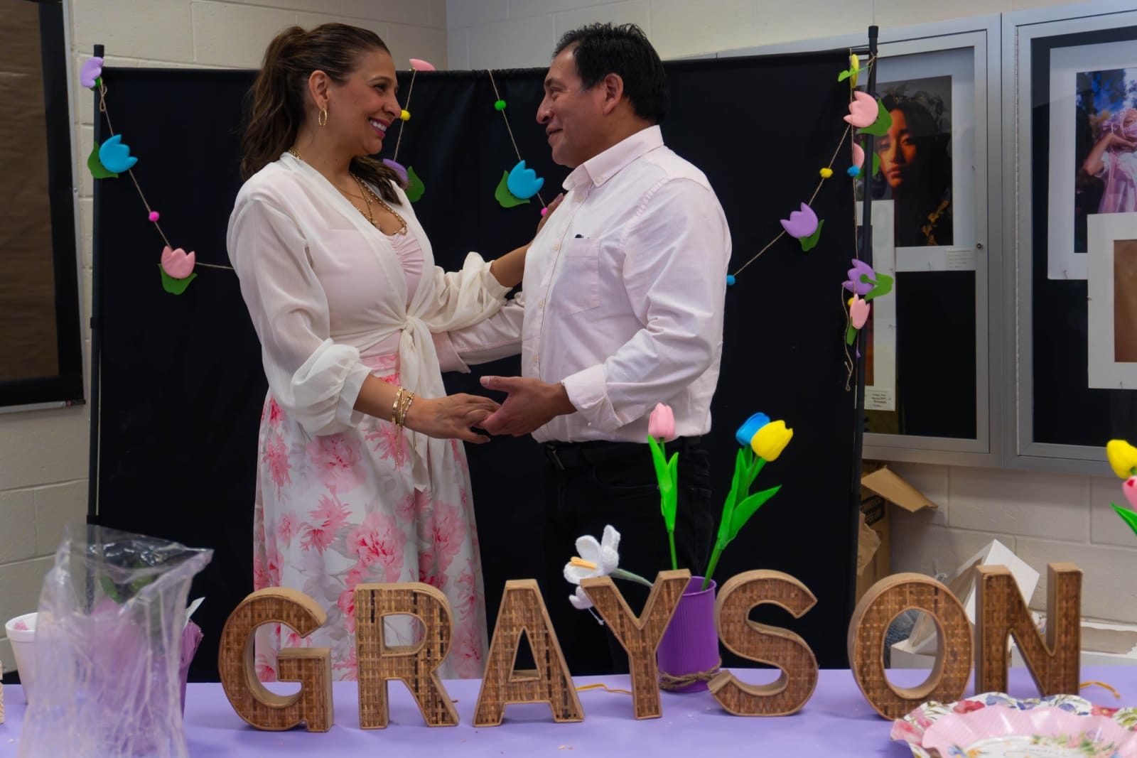 Couple standing by a Grayson sign display / grayson