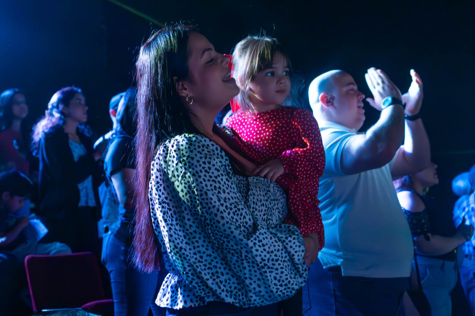 Mother holding her child during worship / grayson