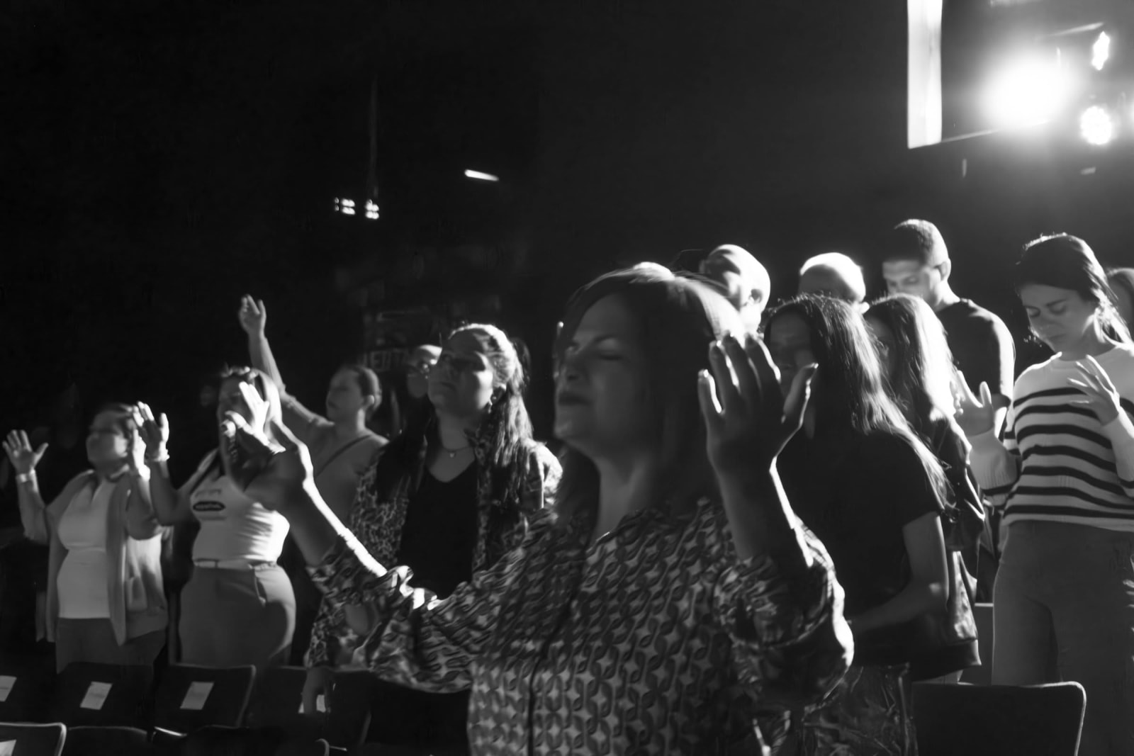 Worshippers with raised hands in black and white / grayson