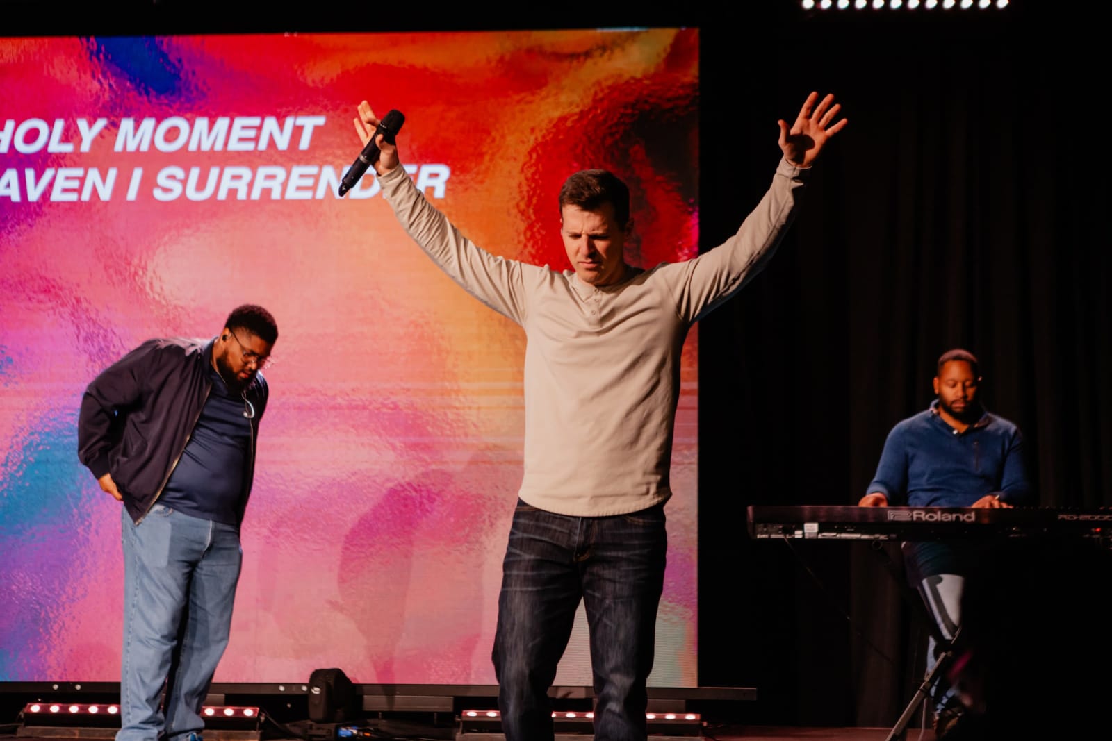 Man worshipping with hands raised  / Gwinnett + Stage