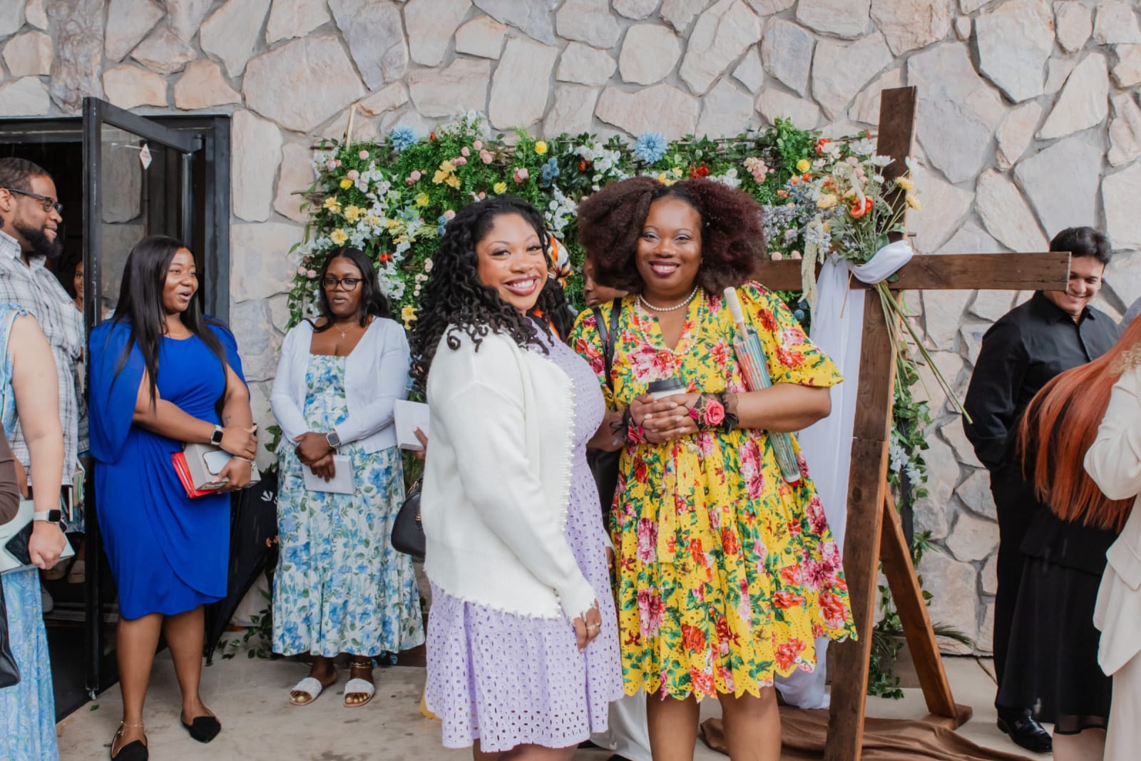 group of women posing by a floral backdrop / gwinnett